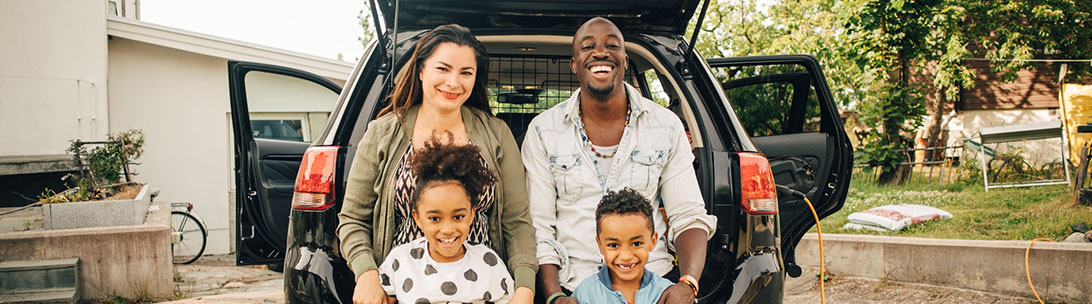 family in front of car